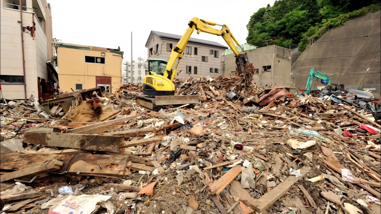 Excavators clear a large pile of construction and demolition waste at a debris-filled site, showcasing professional Debris Removal Services Kent WA for cleanup and site preparation.